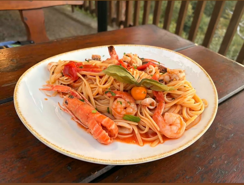 Linguine ai frutti di mare servite sulla tavola in legno con vista