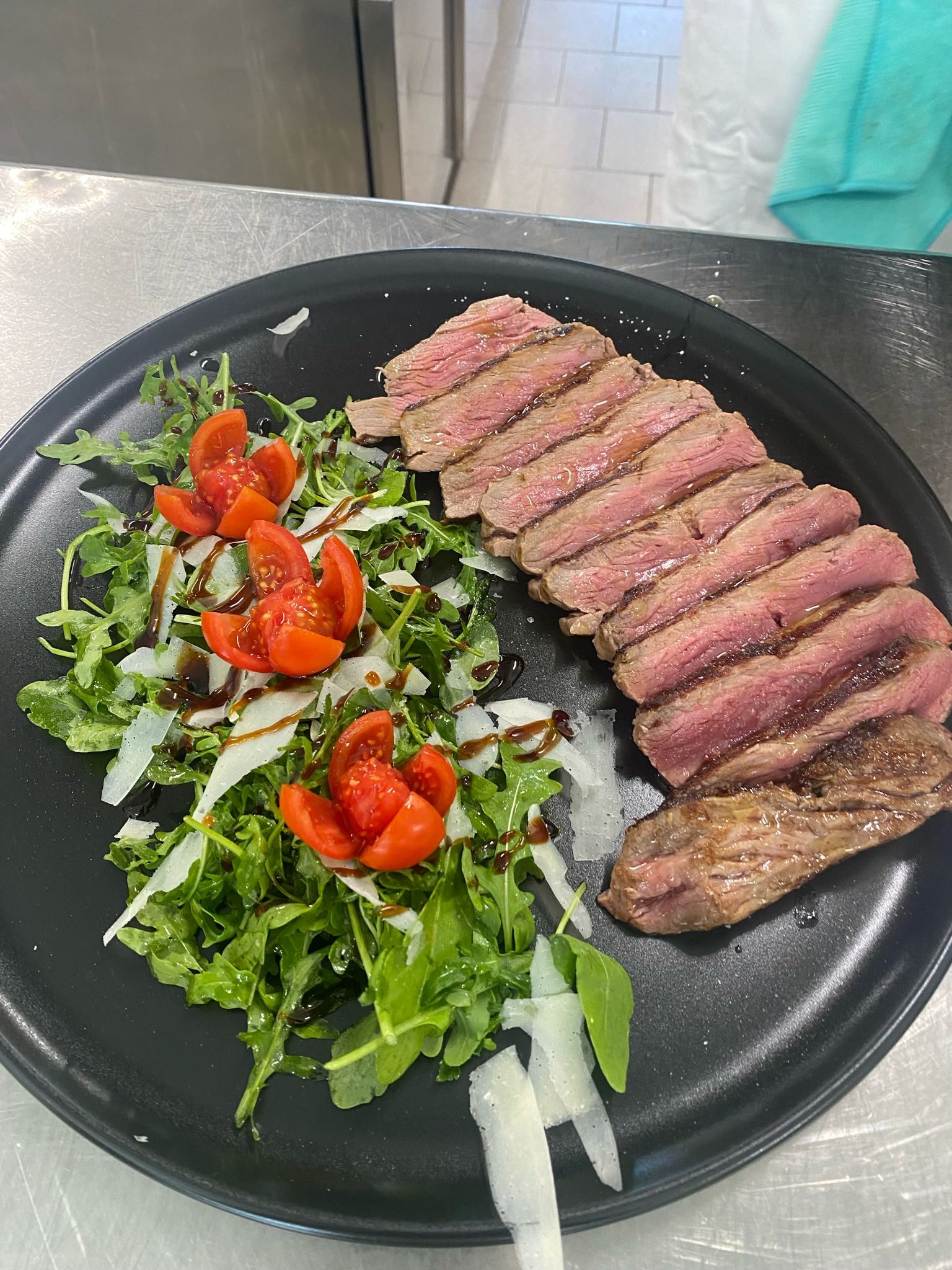 Sliced beef tagliata with rocket, parmesan cheese, and cherry tomatoes